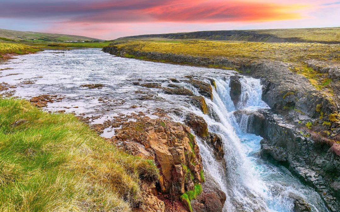red sky over waterfall