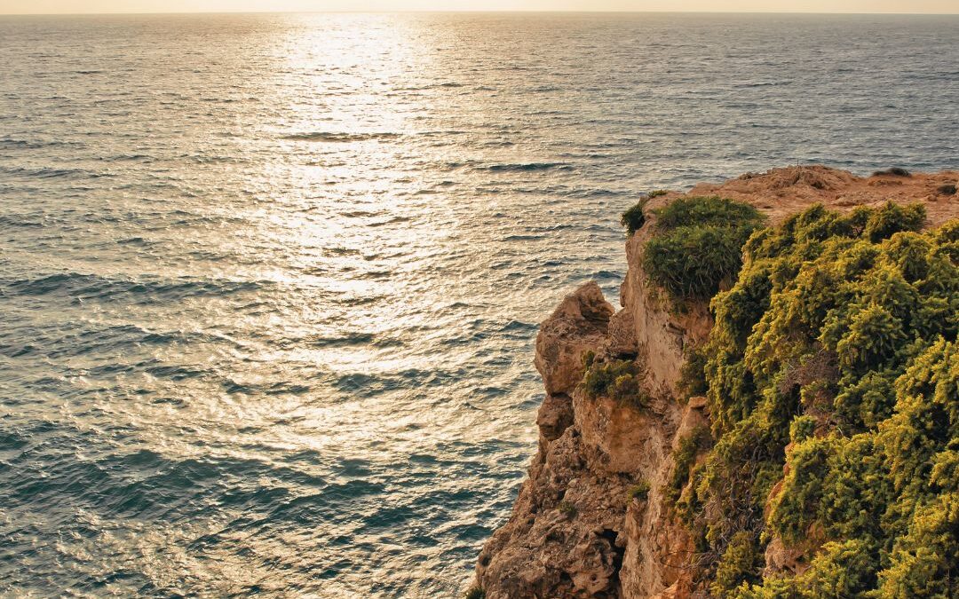 sun on sea with cliff