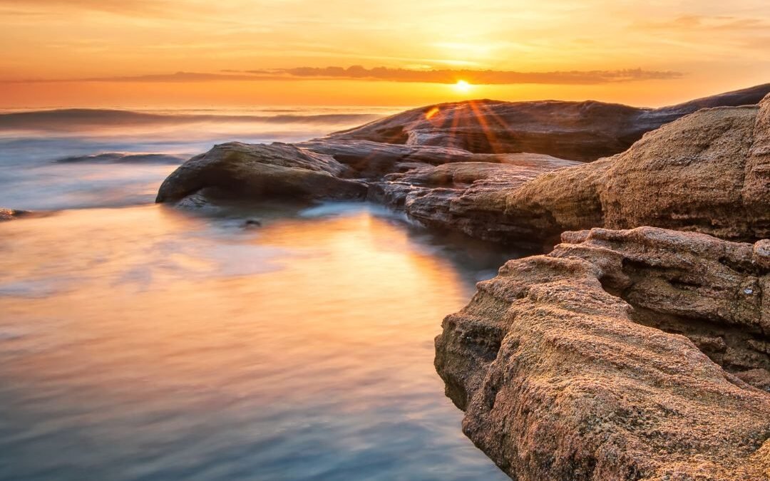 sunrise over ocean rocks