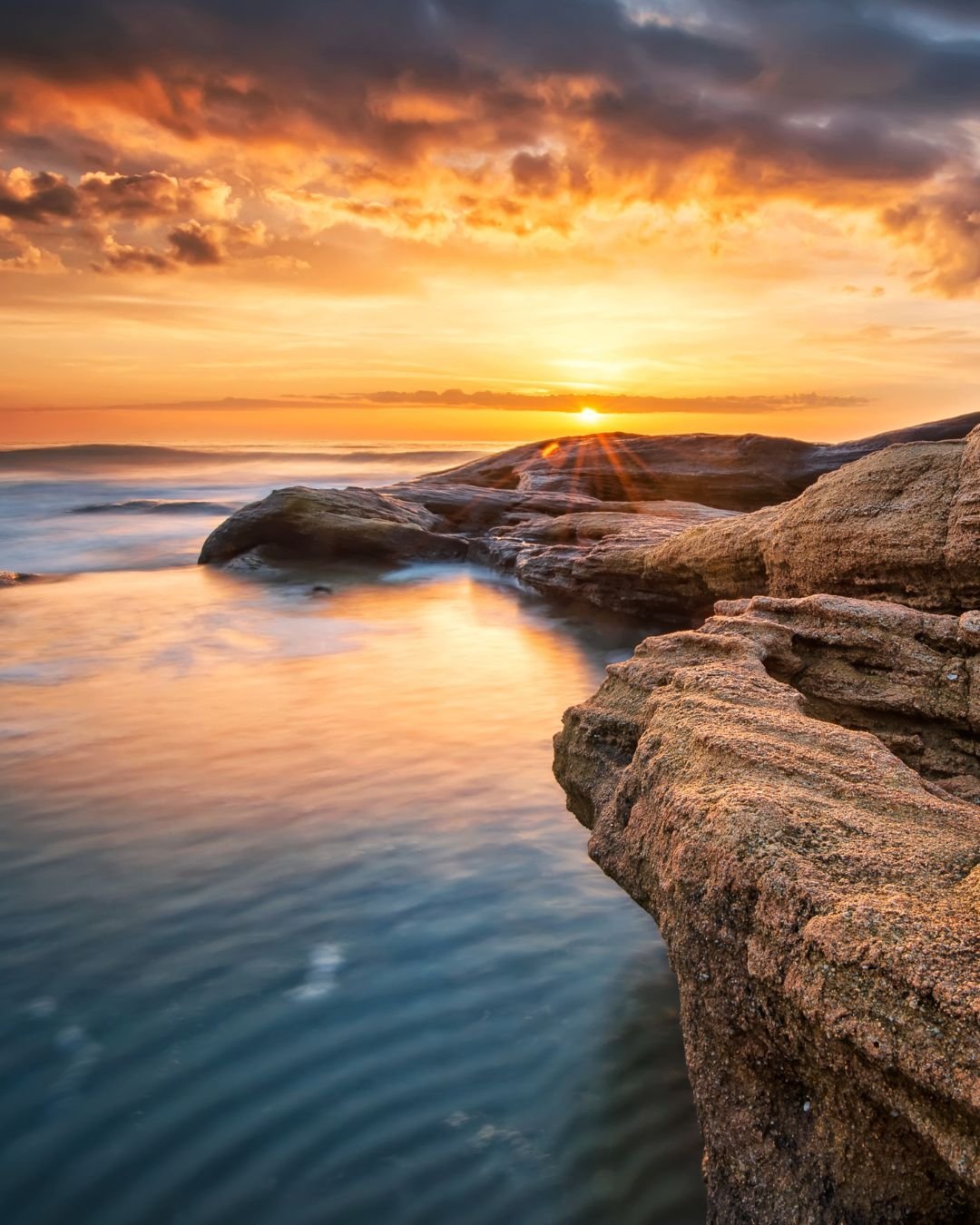 sunrise over ocean rocks