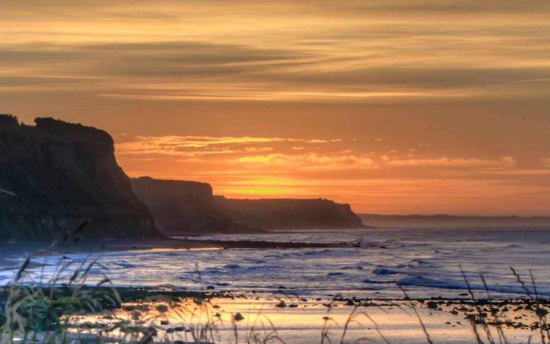 sunset sky over see with cliffs