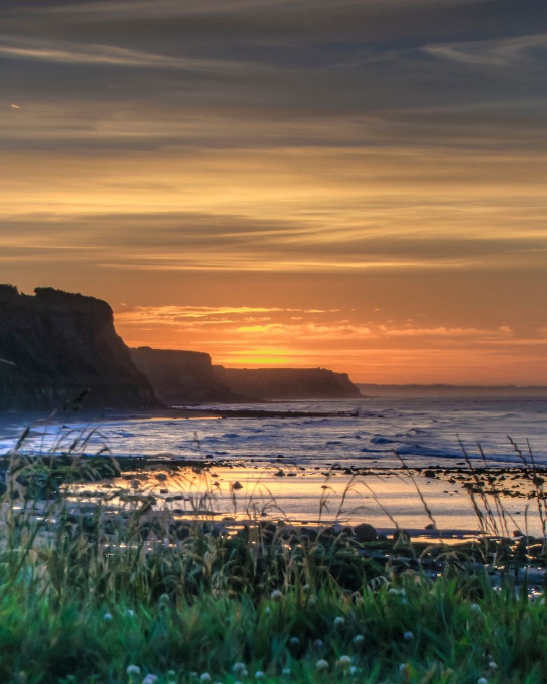 sunset sky over see with cliffs
