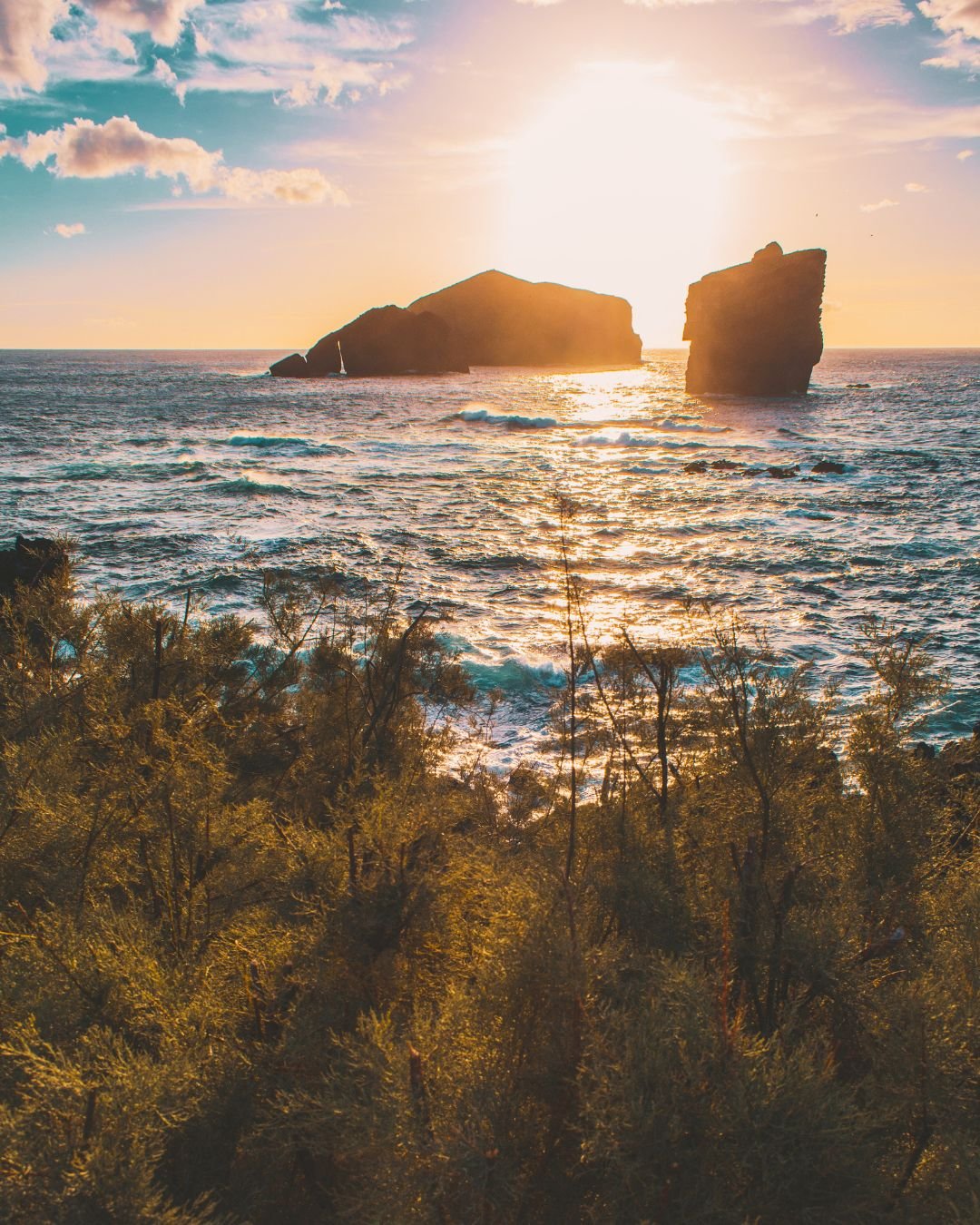 sun over ocean rocks