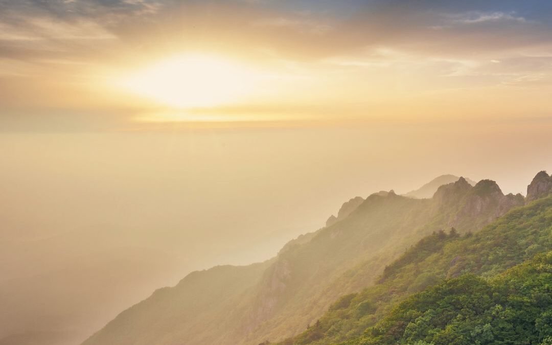 sun over valley with mist