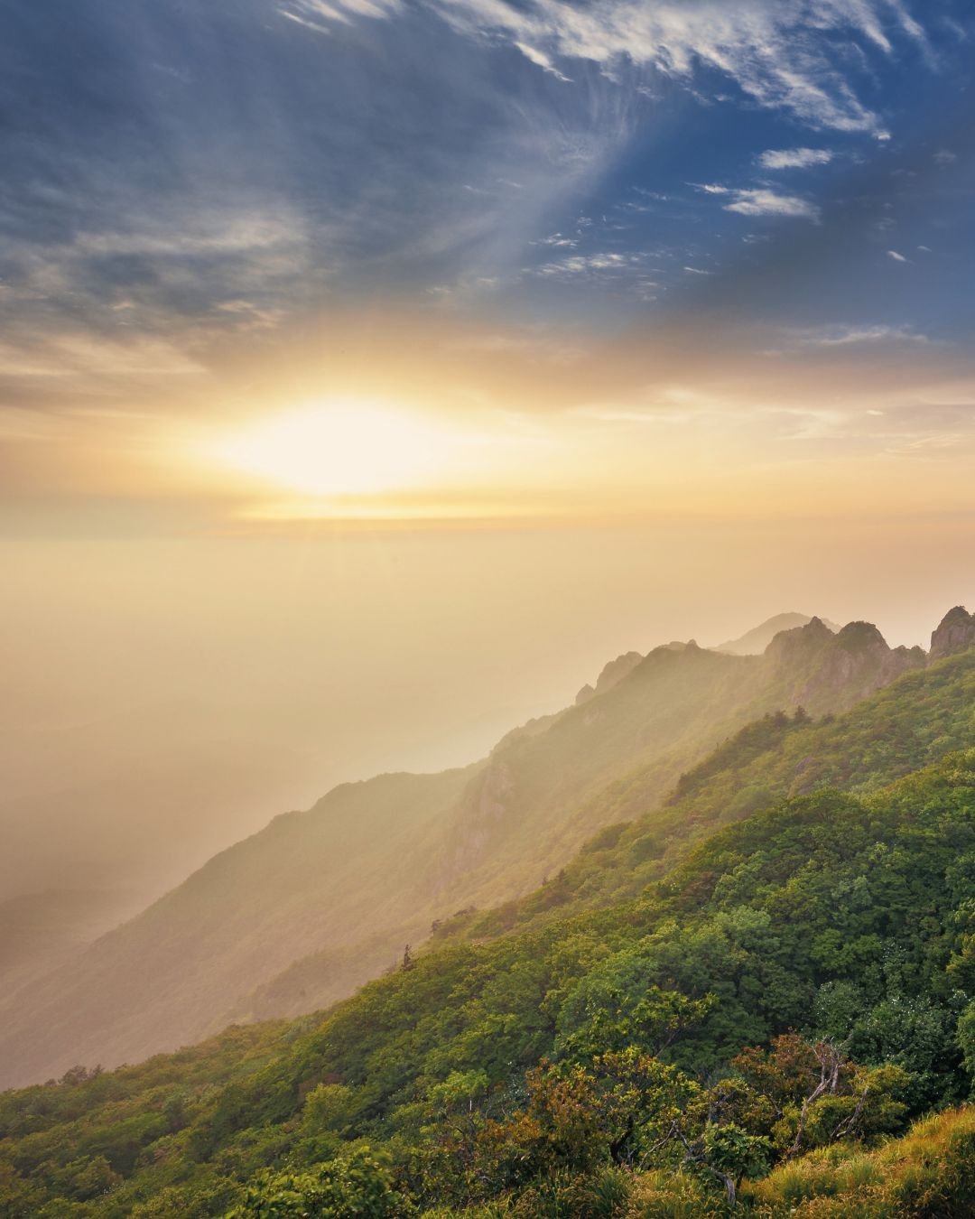 sun over valley with mist