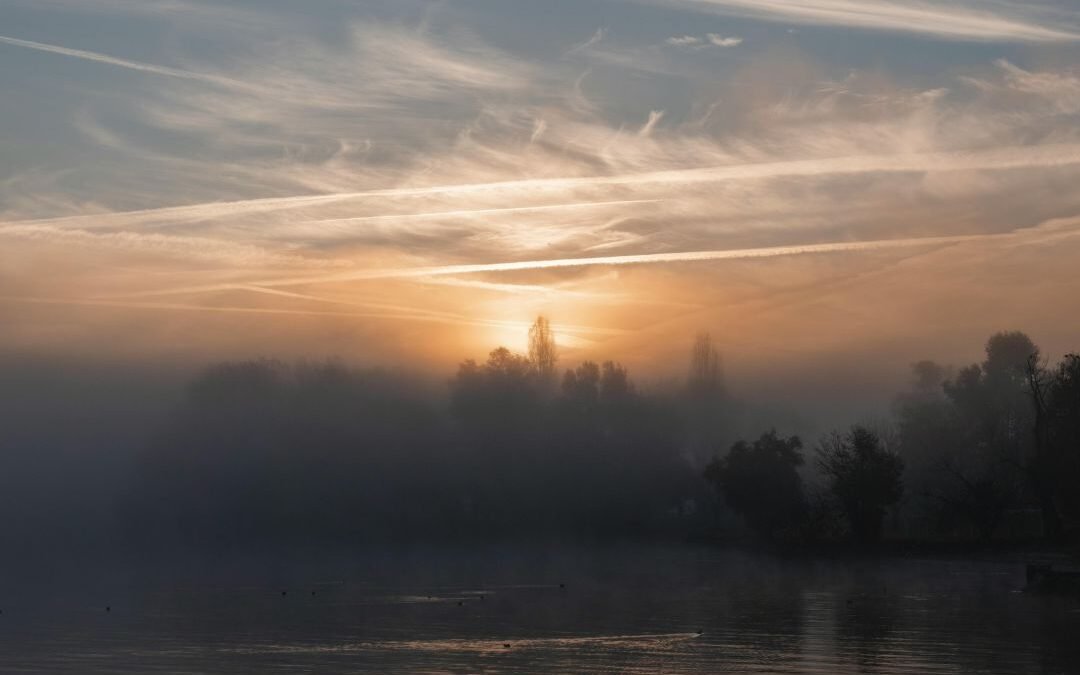 sun through mist over water