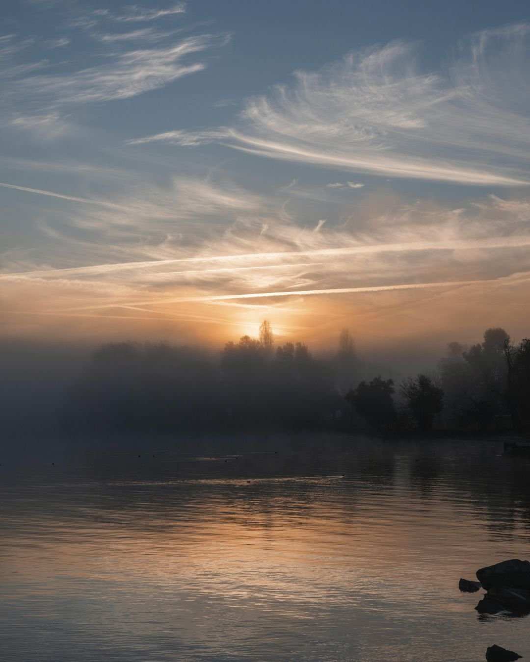 sun through mist over water